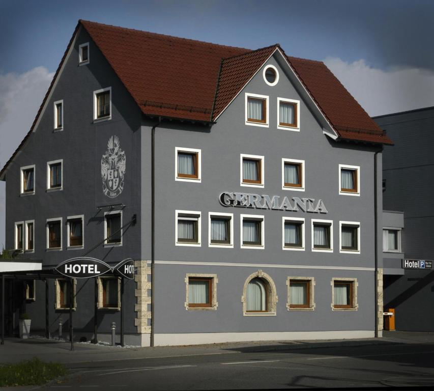 ロイトリンゲンにあるHotel Germaniaの茶色の屋根の白い大きな建物