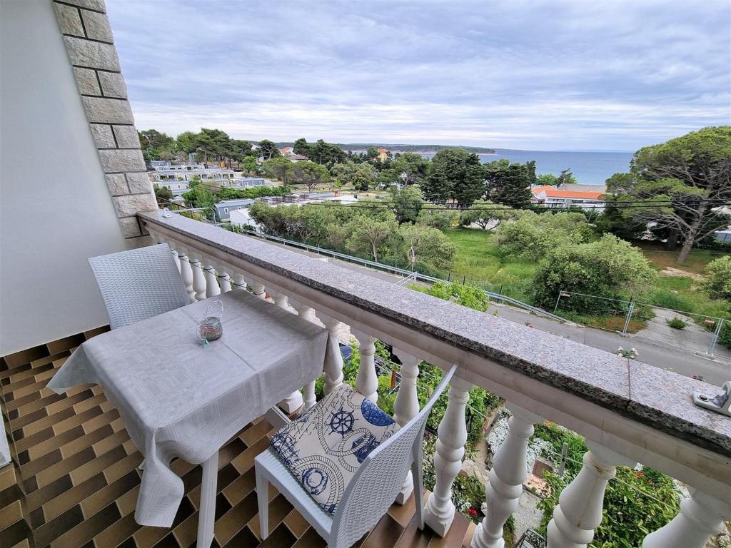 a balcony with a table and chairs and the ocean at Apartment House Kastelan in Banjol