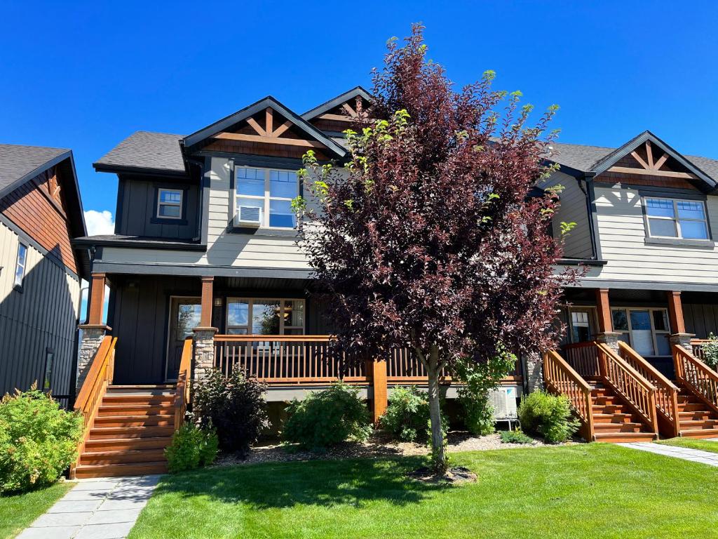 una casa grande con un árbol en el patio en Perfect base Invermere 3bd townhouse mt views with garage, en Invermere