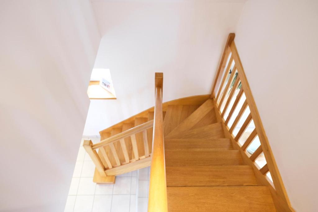 a wooden staircase in a room with white walls at Lescoat-le petit paradis in Plestin-les-Grèves