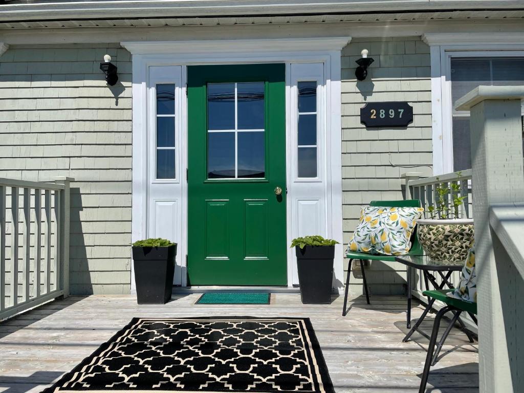 una puerta verde en una casa con patio en Harbour Guesthouse, en Clark's Harbour