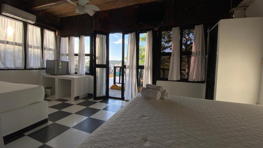 a bedroom with a bed and a checkered floor at Akela Gaira Hotel in Santa Marta
