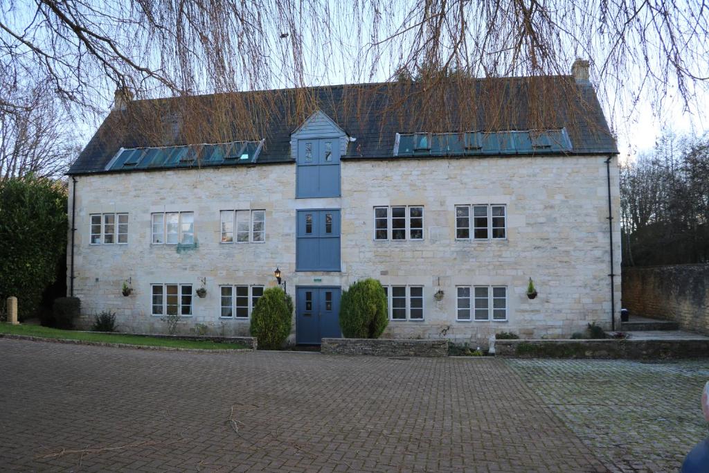 um grande edifício de tijolos brancos com uma torre de relógio em Flat 1 - The Old Mill - Bowbridge Lock - Stroud em Stroud