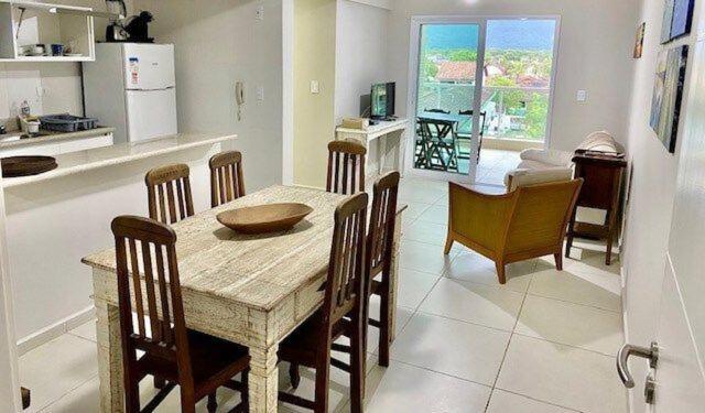 a kitchen and dining room with a table and chairs at Lazer completo 150 mts praia - apto novo Maitinga in Bertioga