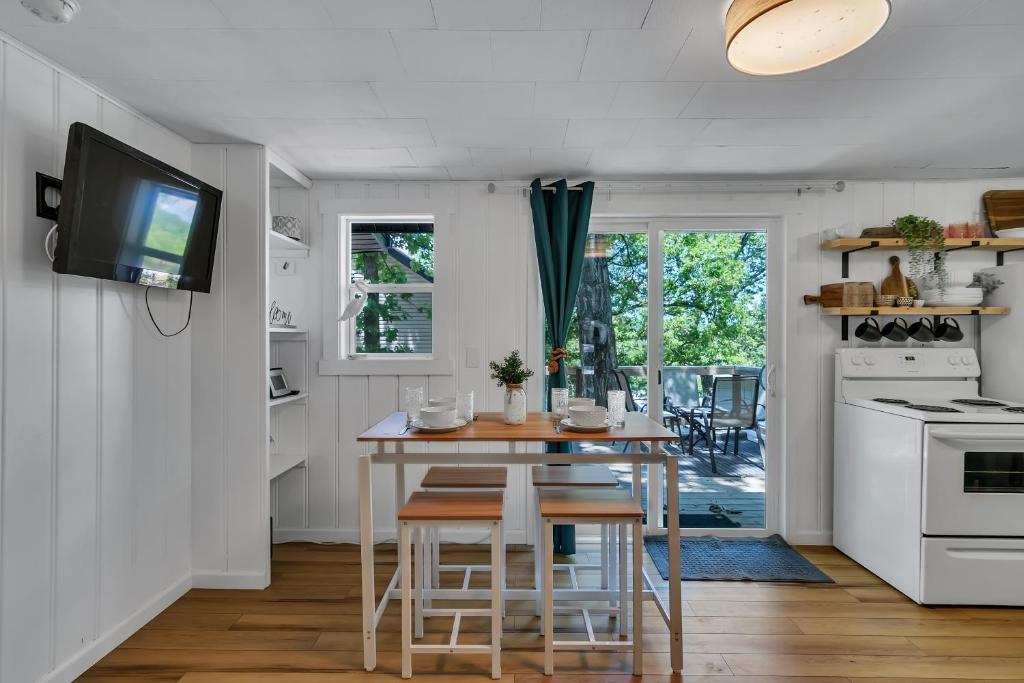 a kitchen with a table and a tv on a wall at Firefly Cottage cabin in Reeds Spring