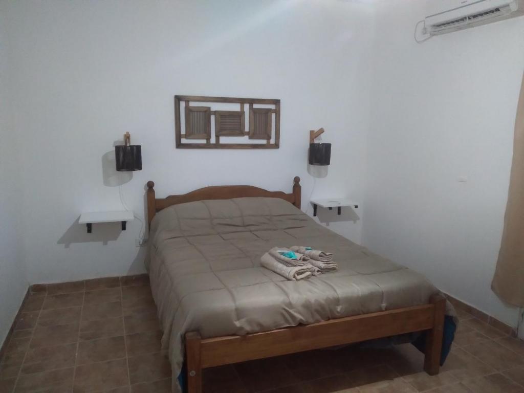 1 dormitorio con cama y espejo en la pared en Complejo La Carlota en San Juan
