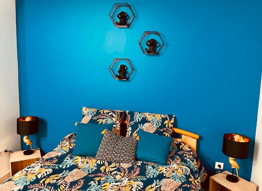 ein blaues Schlafzimmer mit einem Bett mit blauer Wand in der Unterkunft La Villa Perroquet in Poncins