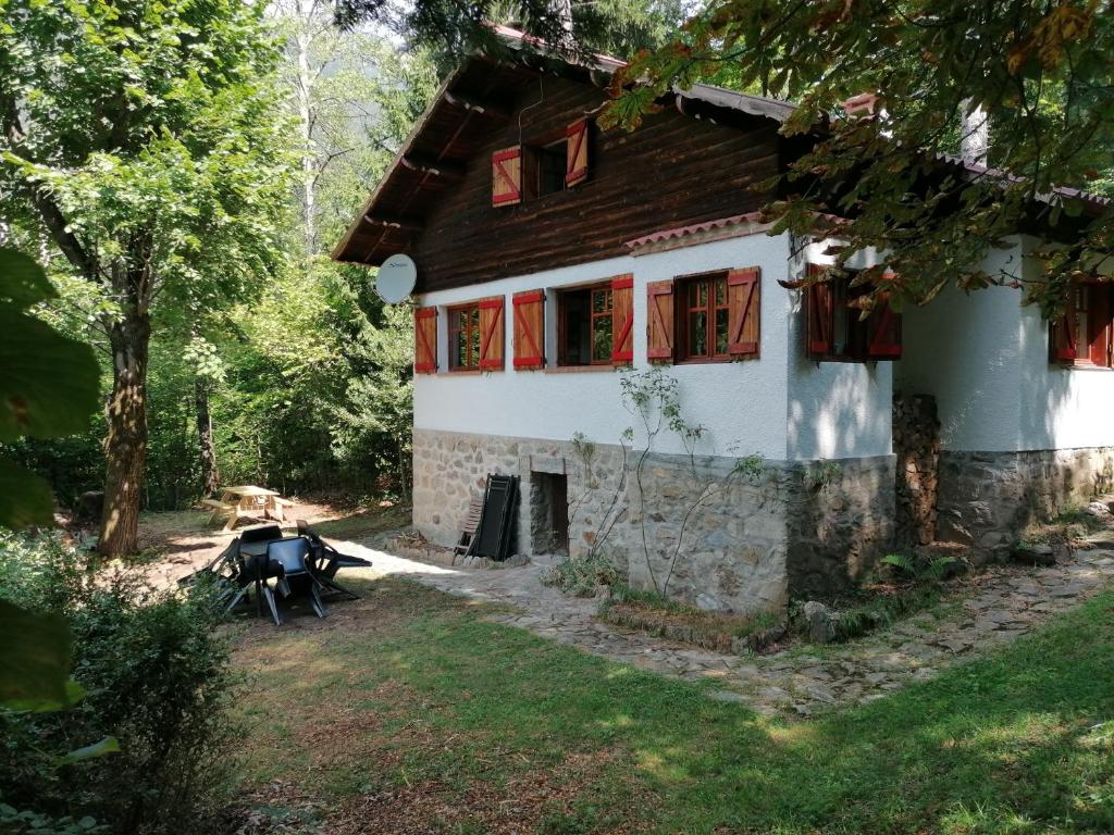 una casa con una mesa de picnic delante de ella en Chalet Le Tyrolien, au coeur du Boréon, en Saint-Martin-Vésubie