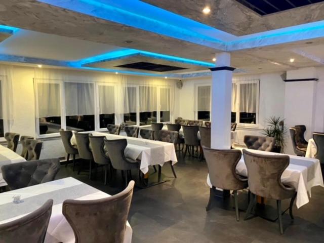 a restaurant with white tables and chairs and blue lights at Louis Hotels in Schmitten
