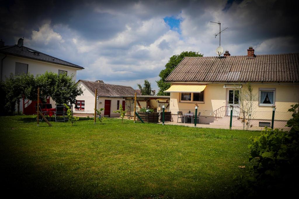 una casa con un patio y una casa con una valla en Ferienhaus Schneckenheisl, en Mindelstetten