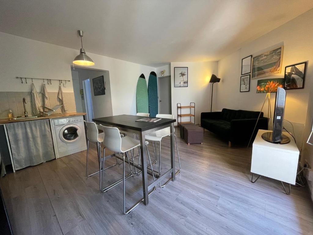 sala de estar con mesa y sala de estar con sofá en Splendide appartement de charme avec patio, parking et plage à 3 minutes, en Biarritz