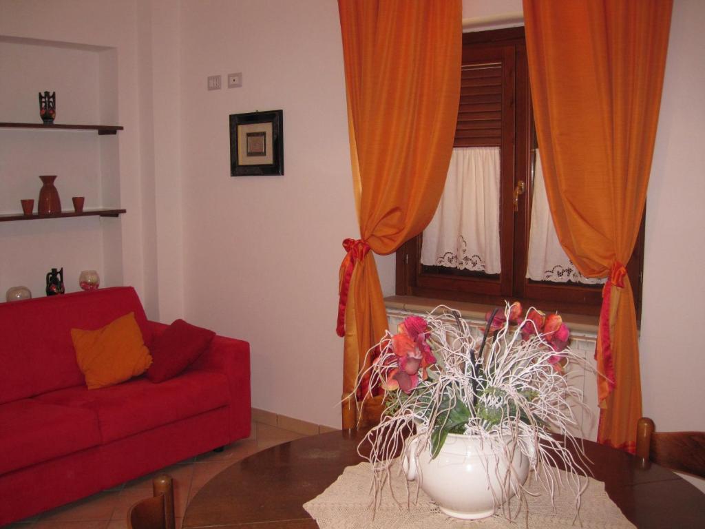 a living room with a red couch and a table at La Casetta Arancione appartamento in Stroncone