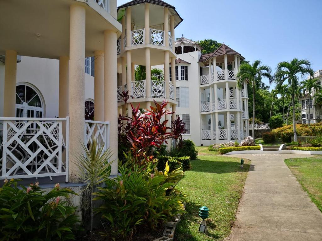 a large white building with a garden in front of it at Stunning views at sky castles Ocho Rios in Eden Bowers