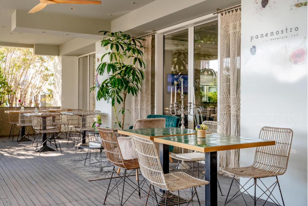 un restaurant avec une table, des chaises, des tables et des fenêtres dans l'établissement Hotel Villa Rosa Riviera, à Rimini