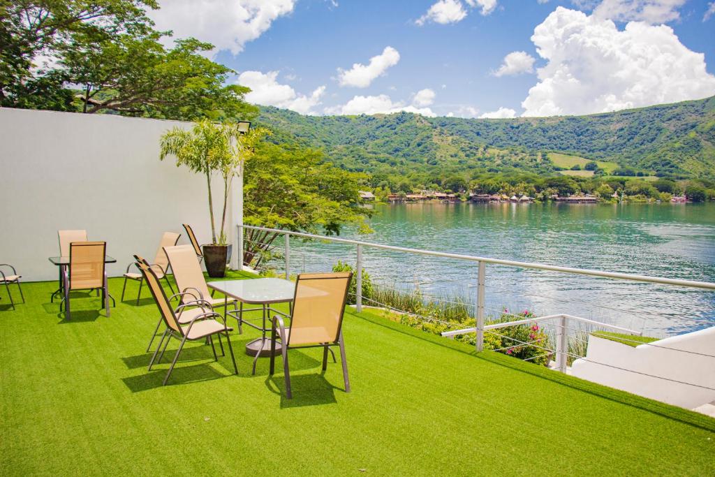 a patio with a table and chairs and a view of the water at Casa Blanca SAMAO in Chichicasta