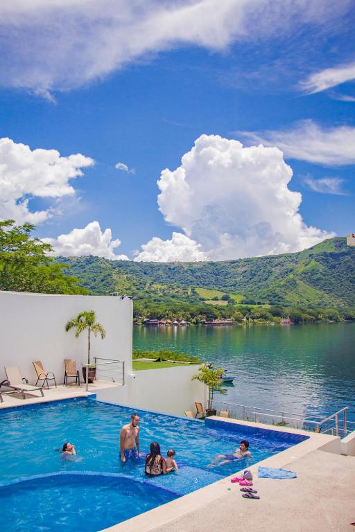 a group of people in a swimming pool next to a lake at Casa Blanca SAMAO in Chichicasta