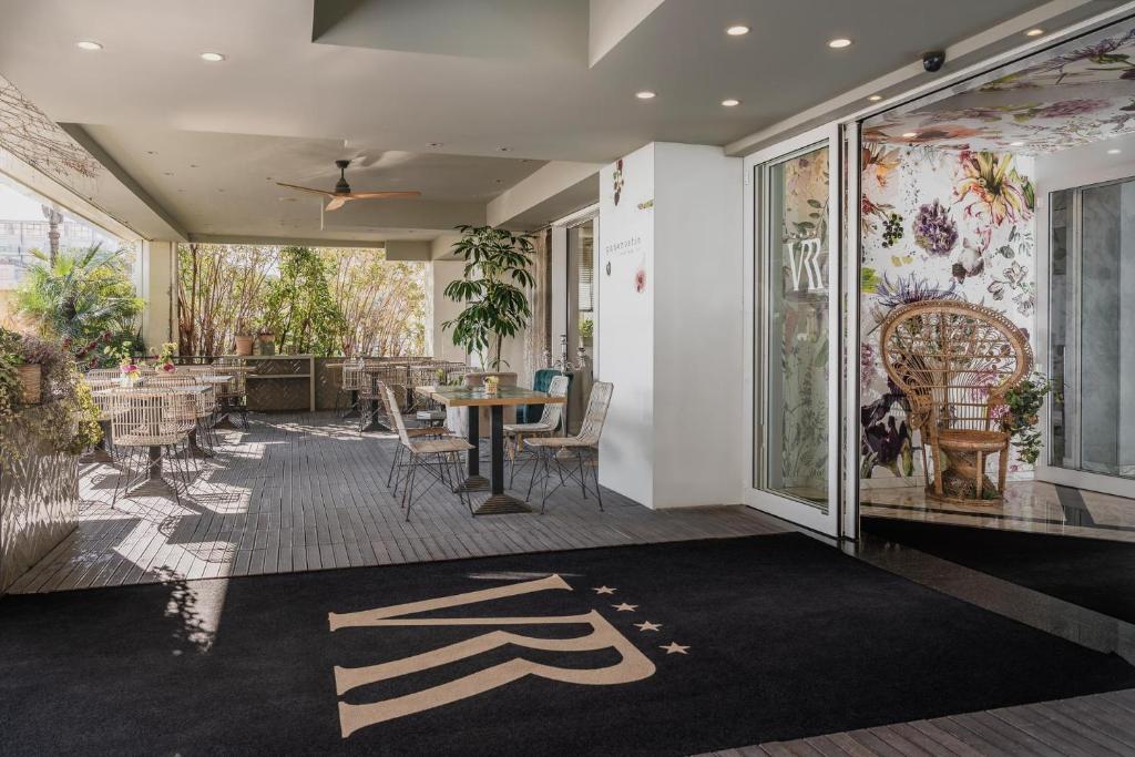 a lobby with a table and chairs on a rug at Hotel Villa Rosa Riviera in Rimini