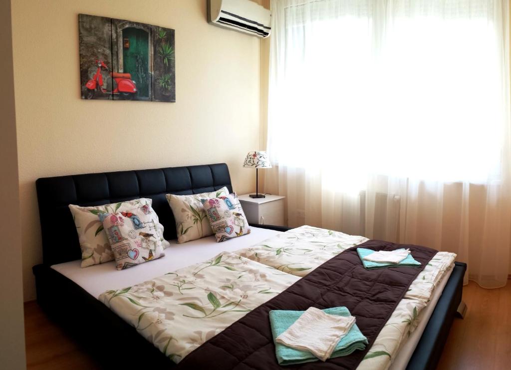 a large bed in a bedroom with a window at Garden House in Budapest