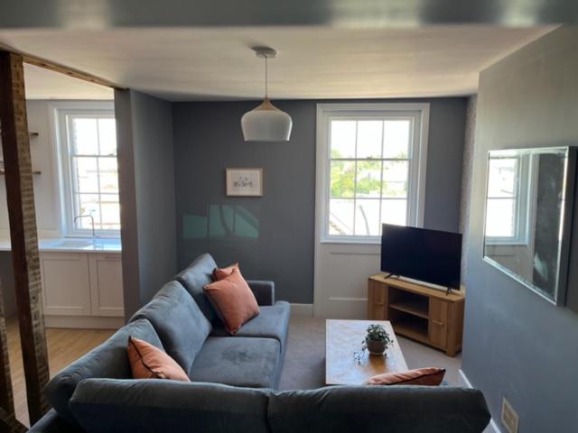sala de estar con sofá azul y TV en Aspen-free parking-Grade II listed-second floor two bedrooms apartment en Huntingdon