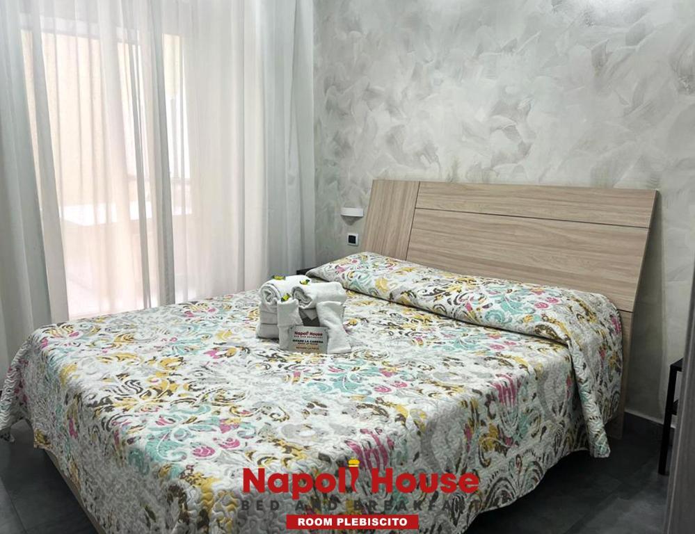 ein Schlafzimmer mit einem Bett mit einer Decke darauf in der Unterkunft B&B Napoli House in Neapel