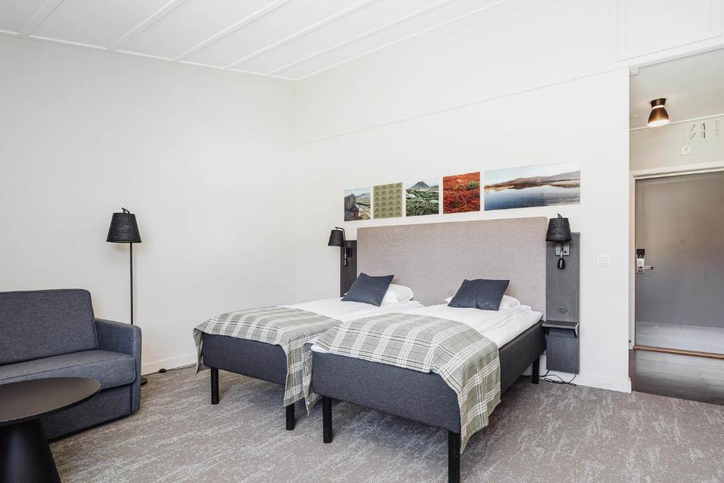 - une chambre avec un lit, un canapé et une chaise dans l'établissement Frich's Hotell og Spiseri Alvdal, à Alvdal
