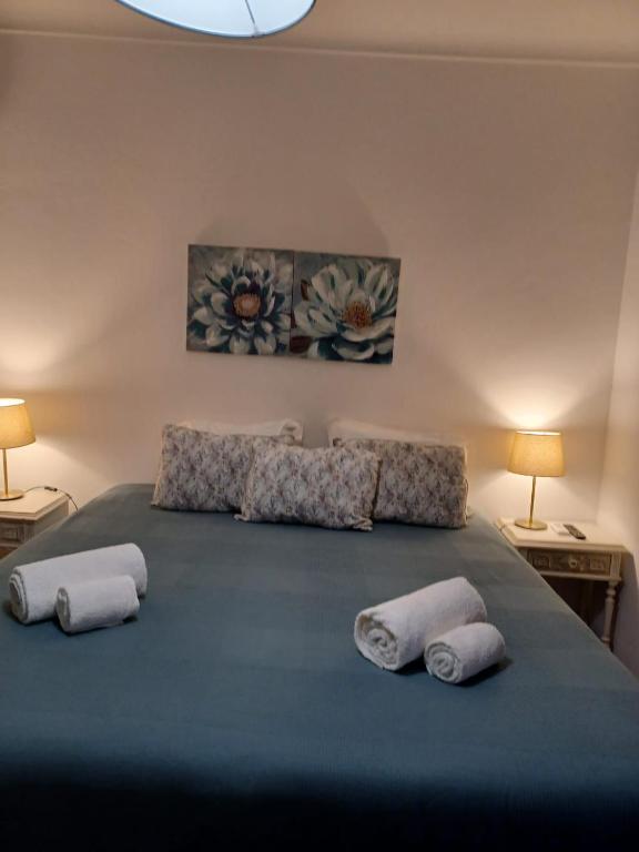 a bedroom with a large bed with towels on it at Moira - Alojamento Local in Reguengos de Monsaraz