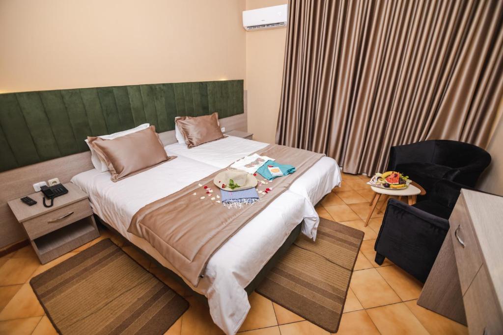 una camera da letto con un letto e un vassoio di cibo sopra di Hotel Alrawabi a Nefza