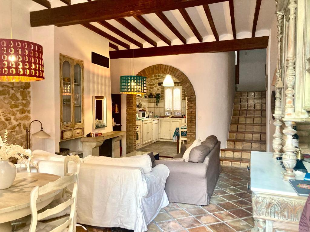 ein Wohnzimmer mit einem Tisch und einer Küche in der Unterkunft Casa Rural Les Avies cerca del mar in La Nucía