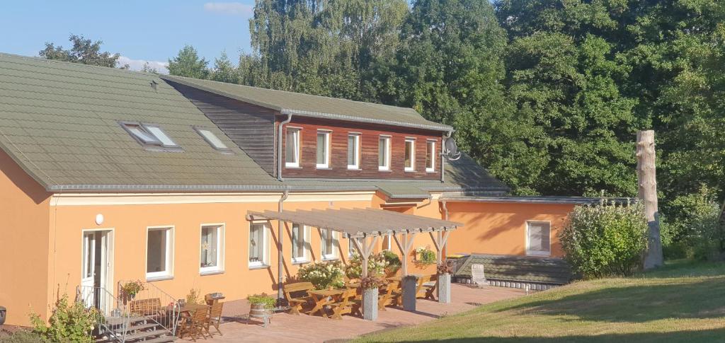 una casa con porche, mesas y techo en Töpferpark en Olbersdorf