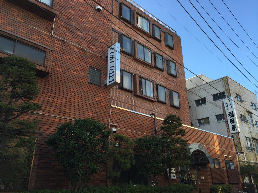 un edificio de ladrillo con un cartel en el costado en Asakusa Hotel Fukudaya, en Tokio