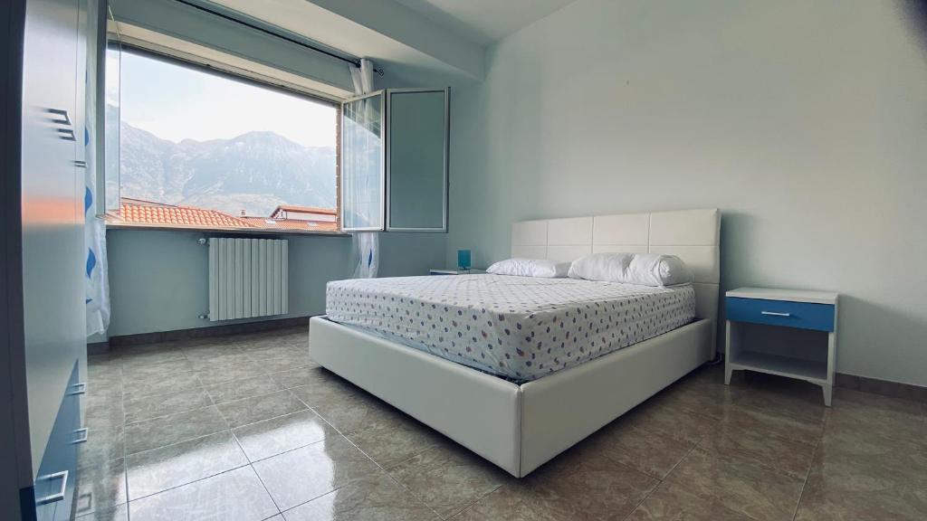a bedroom with a bed and a large window at Oasi Home in Sulmona
