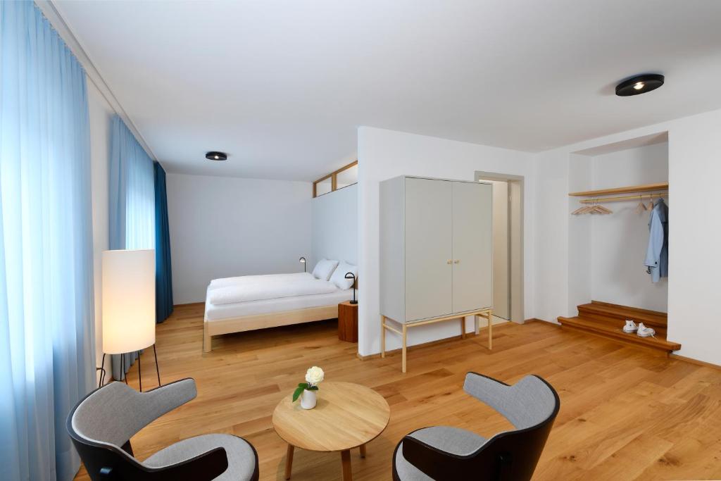 Zimmer mit einem Bett, 2 Stühlen und einem Tisch in der Unterkunft Gasthof zum weissen Rössli in Erschwil