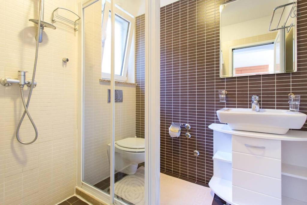 a bathroom with a toilet and a sink and a shower at Apartments Villa Dinka in Opatija