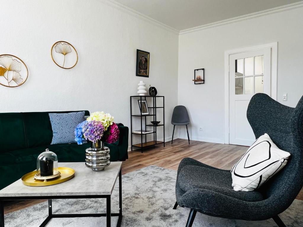 a living room with a green couch and a table at Das Stader Domizil in Stade