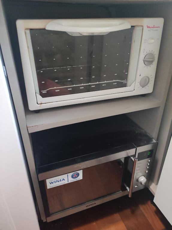 a microwave oven sitting on top of a shelf at Studio indépendant dans un maison in Saint-Denis