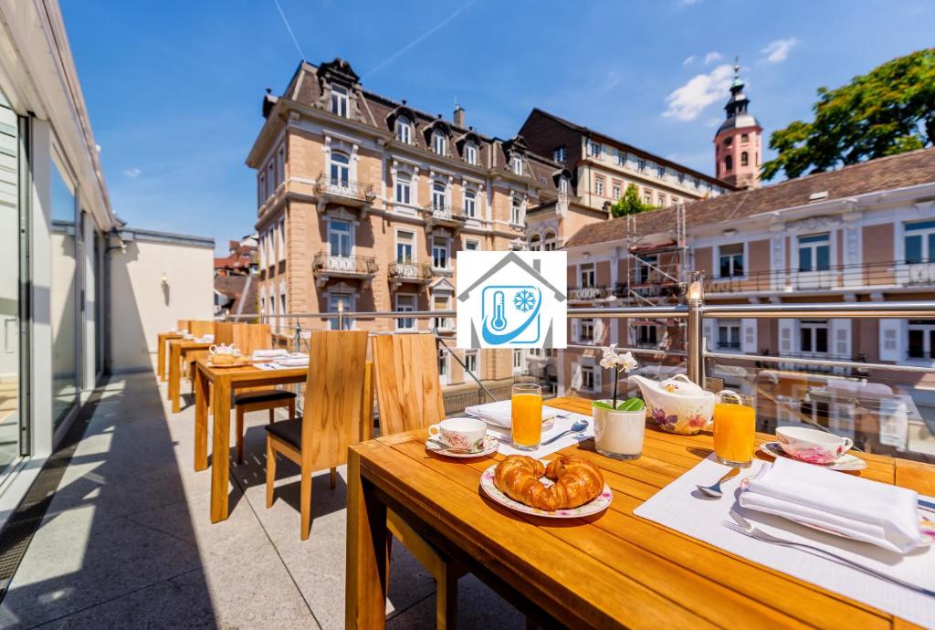 eine Reihe von Tischen auf dem Balkon eines Gebäudes in der Unterkunft ART HOTEL HOUSE ONE in Baden-Baden