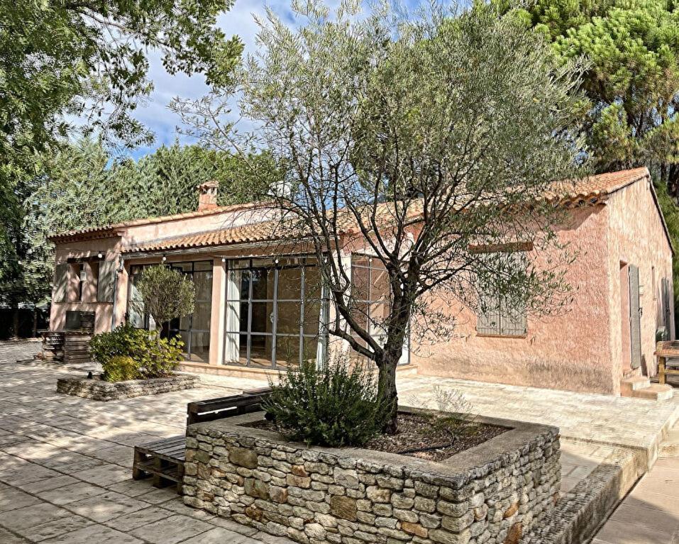 a brick building with a tree in front of it at Chambre d’hôtes l’Orange Bleue in Rustrel