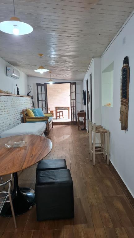 a living room with a table and a dining room at Casa Paúba 80m do Mar in Maresias