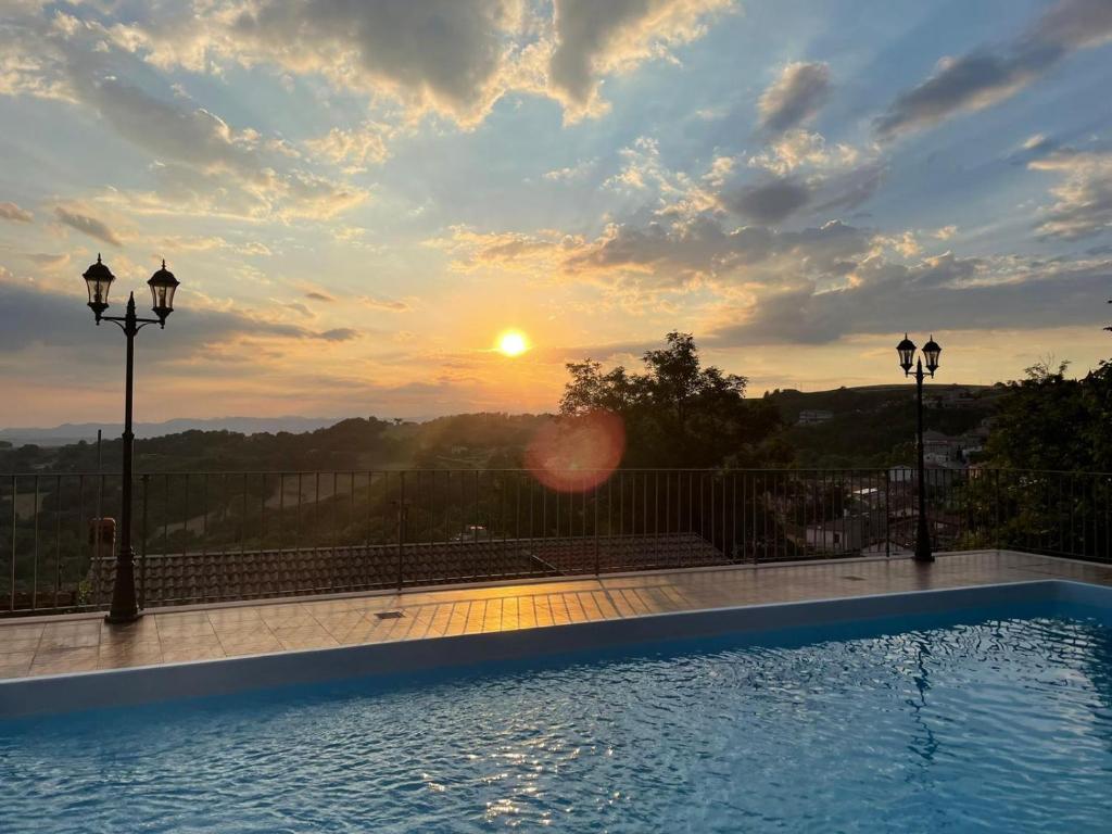 a swimming pool with the sunset in the background at Affittacamere Bellavista in San Marco dei Cavoti