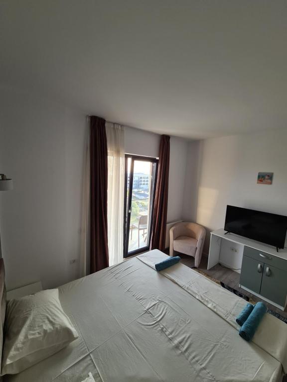 um quarto com uma cama grande e uma janela em Apartament Mamaia-Nord em Mamaia Nord – Năvodari