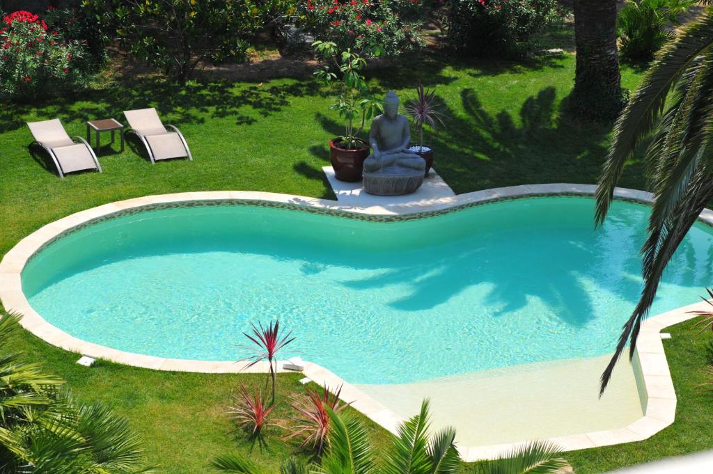 a swimming pool in a yard with two lawn chairs at Villa Valflor chambres d'hôtes et appartements in Marseille