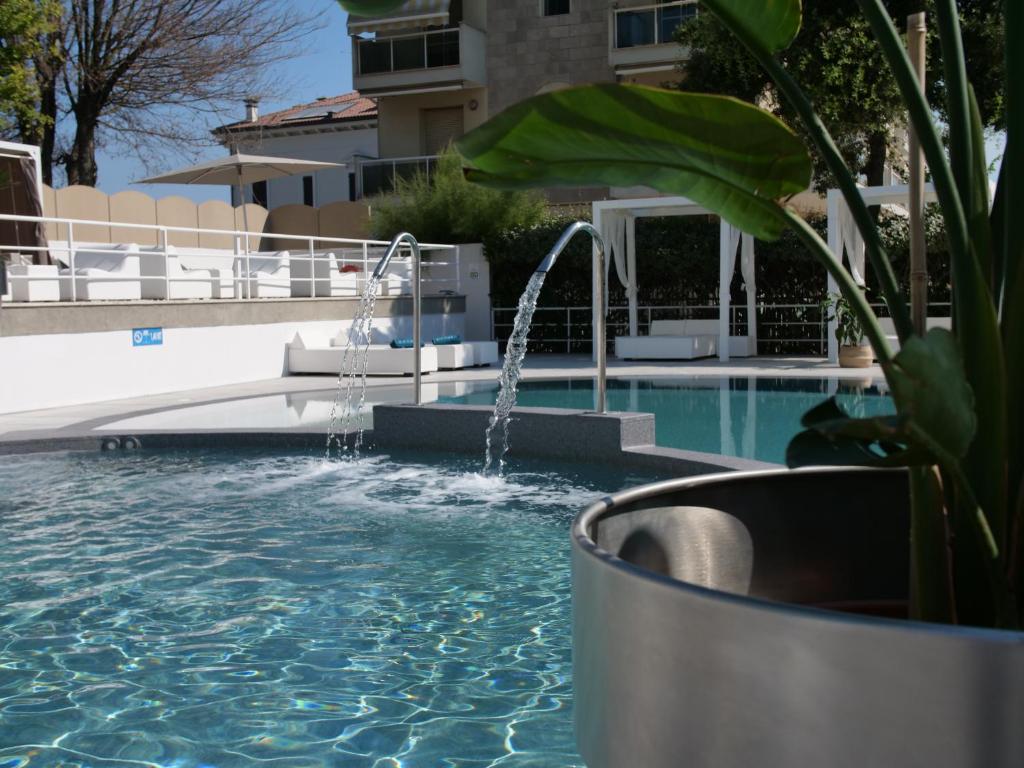 uma piscina com uma fonte no meio em Oxygen Lifestyle Hotel em Rimini