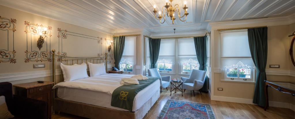 a bedroom with a bed and a chandelier and windows at Hotel Turkish House in Istanbul