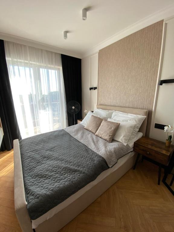 um quarto com uma cama grande e uma janela grande em Apartament Nowe Zatorze 92 em Olsztyn