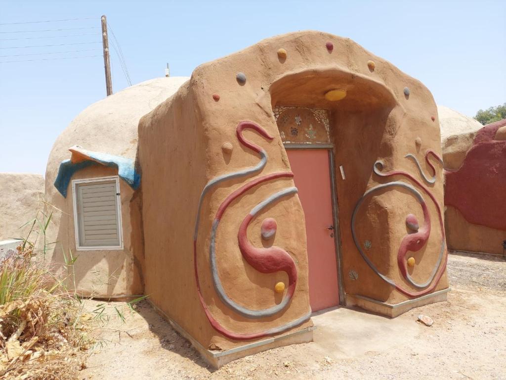una casa con forma de cueva con puerta en Kibbutz Lotan Eco-Campus, 
