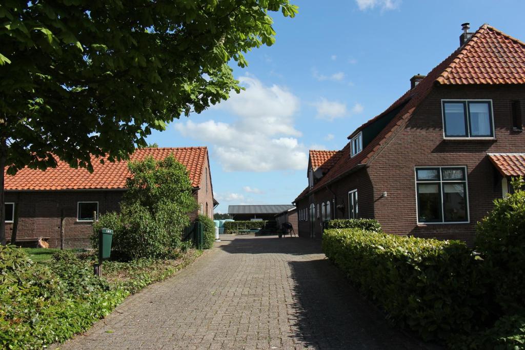 a cobblestone street between two brick houses at Hofstay195 in Achterveld