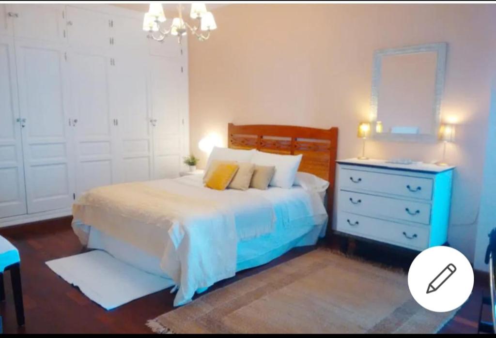 - une chambre avec un lit, une commode et un miroir dans l'établissement Piso Ribera del Marisco, à El Puerto de Santa María