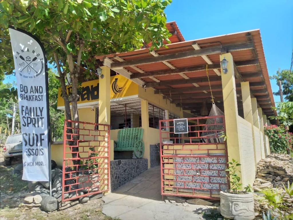 una pequeña casa con un cartel delante en Bananoz Surfhouse en Transito