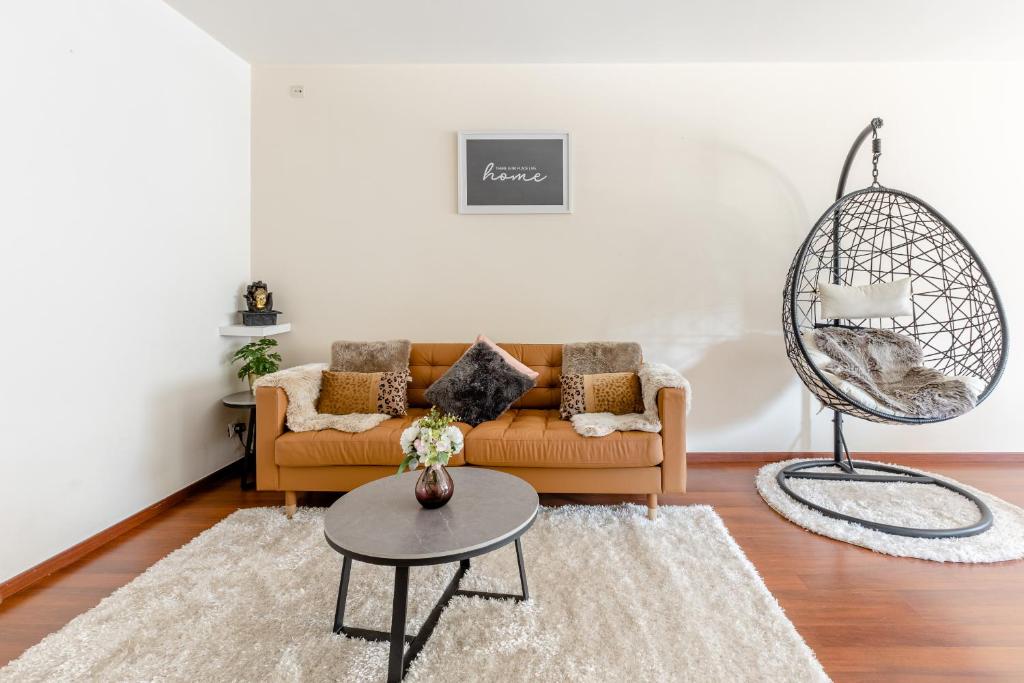 ein Wohnzimmer mit einem Sofa und einem Tisch in der Unterkunft Luxe apt with parking & garden in wilrijk antwerp in Antwerpen