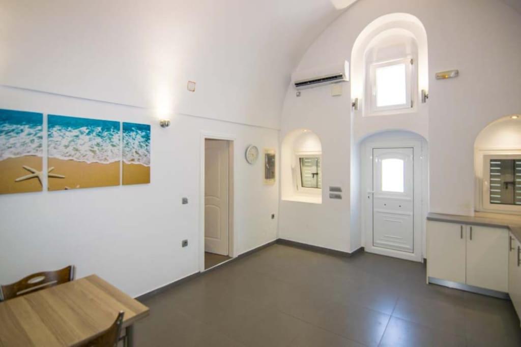 a large white room with a table and a window at Kafenes Home in Mesaria
